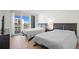 Bright bedroom featuring two beds, a balcony with a view, and modern furnishings at 1430 Gulf Blvd # 603, Clearwater Beach, FL 33767