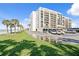 Beachfront condo featuring an expansive parking lot, beach access, and lush landscaping at 1430 Gulf Blvd # 603, Clearwater Beach, FL 33767