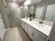 Bright bathroom featuring a double sink vanity with white cabinetry and a glass-enclosed shower at 16683 Shell Bay Dr, Land O Lakes, FL 34638