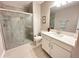 Well-lit bathroom featuring a glass-enclosed shower and a white vanity with a stone countertop at 16683 Shell Bay Dr, Land O Lakes, FL 34638