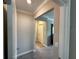 Hallway with neutral colored walls leading to carpeted bedrooms at 16683 Shell Bay Dr, Land O Lakes, FL 34638