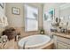 Elegant bathroom features soaking tub with tile surround and granite countertops at 17517 Bright Wheat Dr, Lithia, FL 33547