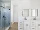 This bright bathroom features double sinks, white cabinets, quartz countertops and a glass enclosed shower at 1753 25Th N Ave, St Petersburg, FL 33713