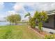 Lush backyard with mature trees and landscaping offers serene views of the adjacent lake at 1816 N Pebble Beach Blvd, Sun City Center, FL 33573