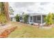 Expansive backyard featuring lush lawn and tropical landscaping creates a private outdoor oasis at 1816 N Pebble Beach Blvd, Sun City Center, FL 33573