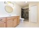 Bathroom featuring a wood vanity, a stylish mirror and a beautifully tiled shower at 1816 N Pebble Beach Blvd, Sun City Center, FL 33573