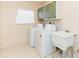 Functional laundry room with washing machine, dryer, utility sink, and storage at 1816 N Pebble Beach Blvd, Sun City Center, FL 33573