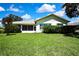 Well-maintained backyard featuring a meticulously kept lawn, shrubbery, and an enclosed patio at 18951 Grand Club Dr, Hudson, FL 34667