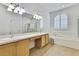 Elegant bathroom with a soaking tub, walk-in shower, and -and- vanities, offering luxury and convenience at 18951 Grand Club Dr, Hudson, FL 34667