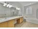 Bright bathroom featuring a large mirror, double sinks, and a separate tub and shower at 18951 Grand Club Dr, Hudson, FL 34667