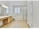 Bright bathroom featuring a soaking tub, walk-in shower, and a vanity with plenty of counter space at 18951 Grand Club Dr, Hudson, FL 34667