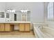 Bathroom with double sink vanity, soaking tub, and neutral tile flooring at 18951 Grand Club Dr, Hudson, FL 34667