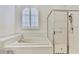 Clean bathroom with a soaking tub, walk-in shower, and a window, creating a spa-like experience at 18951 Grand Club Dr, Hudson, FL 34667
