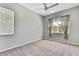 Bedroom with gray walls, neutral carpeting, ceiling fan, and natural light at 18951 Grand Club Dr, Hudson, FL 34667