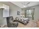 Cozy bedroom featuring a comfortable chair, ceiling fan, and a window with natural light at 18951 Grand Club Dr, Hudson, FL 34667