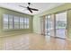 Bedroom featuring neutral tones, ceiling fan, and sliding glass doors with lanai access at 18951 Grand Club Dr, Hudson, FL 34667