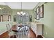 Dining area with wood floors, cabinet, chandelier and windows with plantation shutters at 18951 Grand Club Dr, Hudson, FL 34667