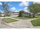 Attractive home with a well-manicured lawn, three-car garage, and mature trees at 18951 Grand Club Dr, Hudson, FL 34667