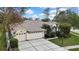 Stunning exterior view of the home featuring a three-car garage and well-manicured landscaping at 18951 Grand Club Dr, Hudson, FL 34667