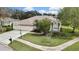Aerial front view of the property featuring a spacious driveway and vibrant landscaping at 18951 Grand Club Dr, Hudson, FL 34667