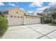 Spacious three-car garage with decorative windows and ample parking on the concrete driveway at 18951 Grand Club Dr, Hudson, FL 34667