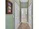 Hallway featuring white closets leading to a well-lit bathroom at 18951 Grand Club Dr, Hudson, FL 34667