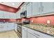 Well-lit kitchen features granite countertops, stainless steel appliances and light gray cabinets at 18951 Grand Club Dr, Hudson, FL 34667