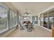 Enclosed lanai with tile floor and a glass table surrounded by seating, offering serene views at 18951 Grand Club Dr, Hudson, FL 34667