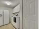 Bright laundry area featuring a white washer and dryer with ample storage space at 18951 Grand Club Dr, Hudson, FL 34667