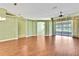 Bright, open living room with hardwood floors, arched doorways, and sliding glass doors to the lanai at 18951 Grand Club Dr, Hudson, FL 34667