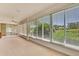 Enclosed patio featuring tile floors, a ceiling fan, and views of a lush green landscape at 18951 Grand Club Dr, Hudson, FL 34667