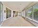 Expansive enclosed patio with tile flooring, ceiling fan, and a sliding door entry to the home at 18951 Grand Club Dr, Hudson, FL 34667