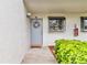 Charming front door with wreath, a window, and greenery, creating an inviting entrance to the home at 2073 Skimmer W Ct # 211, Clearwater, FL 33762