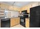 Kitchen showcases black appliances, wood cabinets, and a sink with faucet at 2073 Skimmer W Ct # 211, Clearwater, FL 33762