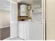 Laundry area inside a closet features a washer, dryer, water heater, and shelving at 2073 Skimmer W Ct # 211, Clearwater, FL 33762