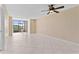 Living room with large windows, ceiling fan, and tile floors offering views of a golf course at 2073 Skimmer W Ct # 211, Clearwater, FL 33762