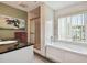 Bright bathroom with a combination shower and tub, a black granite vanity, and a large window at 20890 Negril Ct # 5, Lutz, FL 33558
