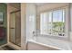 Bright bathroom featuring a tub with jets and a tiled shower enclosure provides both relaxation and convenience at 20890 Negril Ct # 5, Lutz, FL 33558