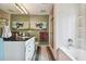 Well-lit bathroom boasts a granite vanity, glass-enclosed shower, and soaking tub, offering a spa-like experience at 20890 Negril Ct # 5, Lutz, FL 33558
