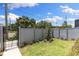 Private, fenced backyard with manicured lawn and established landscaping, accessible through a black metal gate at 2205 16Th N St, St Petersburg, FL 33704
