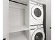 Organized laundry area with stacked washer and dryer and open shelving for storage at 2205 16Th N St, St Petersburg, FL 33704