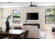 Cozy living room with a modern media console and a view of the landscaped yard through large windows at 2205 16Th N St, St Petersburg, FL 33704