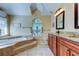 Bathroom showcasing a luxurious tub, stylish fixtures, and a large window for natural light at 2217 Windsong Ct, Safety Harbor, FL 34695