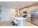 Modern kitchen with gray cabinets, stainless steel appliances, and a quartz countertop island at 2334 Audubon Preserve Ln, Lutz, FL 33558