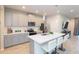 Modern kitchen with gray cabinets, stainless steel appliances, and a quartz countertop island at 2334 Audubon Preserve Ln, Lutz, FL 33558