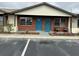 Cozy brick condo featuring a blue front door with a festive wreath and well-maintained landscaping at 24862 Us Highway 19 N # 1504, Clearwater, FL 33763