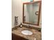 Bathroom features a speckled granite countertop, wooden cabinets, and a framed mirror at 2985 W Knights Ave # 2985, Tampa, FL 33611