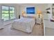Bright bedroom features a serene atmosphere with light colors, a large window, and beach-themed artwork at 2985 W Knights Ave # 2985, Tampa, FL 33611