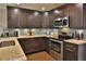 Stylish kitchen showcasing granite countertops, stainless steel appliances, and dark wood cabinets at 2985 W Knights Ave # 2985, Tampa, FL 33611