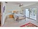 Serene main bedroom with carpet flooring, a ceiling fan, a king-size bed, and balcony access with natural light at 2985 W Knights Ave # 2985, Tampa, FL 33611